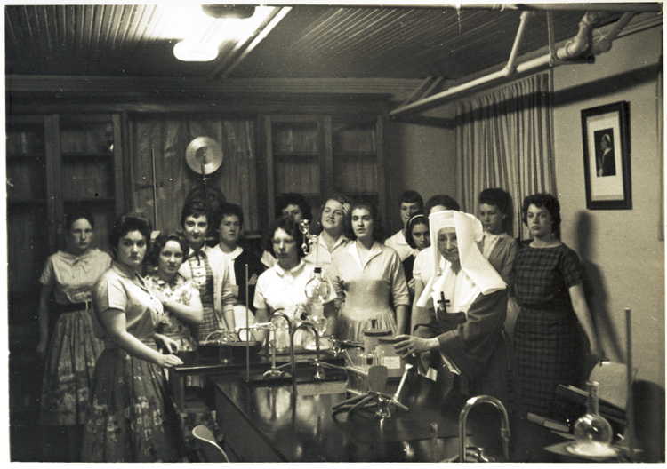 Reproduction d’une photographie d’une religieuse de la congr&eacute;gation des Filles de la sagesse et de ses &eacute;l&egrave;ves lors d’un cours de chimie, Sault Sainte-Marie (Ontario), ca 1950.