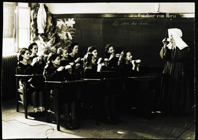Reproduction d’une photographie d’une religieuse de la congr&eacute;gation des Filles de la sagesse et de ses &eacute;l&egrave;ves lors d’un cours d’hygi&egrave;ne sur les soins dentaires, &agrave; l’&eacute;cole Montfort, rue Dupuis, Vanier (Ontario), 1947.