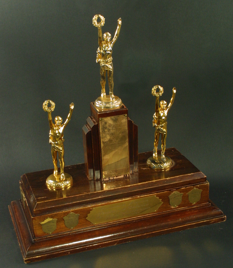 Reproduction d’une photographie du Troph&eacute;e Association de la jeunesse franco-ontarienne au concours de fran&ccedil;ais, section secondaire, premier prix, comprenant la liste des r&eacute;cipiendaires de 1959-1970, 1970.