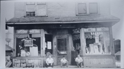 Reproduction d’une photographie du Magasin Lemelin et Belleau, au coin des rues Welland et Queen, Welland (Ontario), ca 1920.
