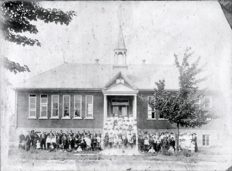 Reproduction d’une photographie des &eacute;l&egrave;ves devant l’&eacute;cole du village de Limoges (Ontario), 1914.