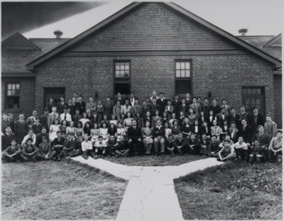 Reproduction d’une photographie des &eacute;l&egrave;ves et des enseignants devant l’&eacute;cole mod&egrave;le bilingue de Embrun (Ontario), ca 1930.